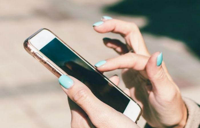 a person typing on a white smart phone